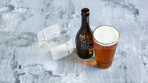 Image of Glass of light beer on white stone background