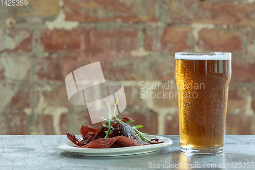 Image of Glass of light beer on the stone table and brick\'s background