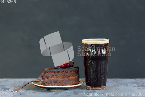 Image of Glass of dark beer on the stone table and grey background