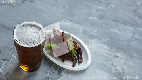 Image of Glass of beer on the stone table and brick\'s background