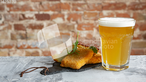 Image of Glass of light beer on the stone table and brick\'s background