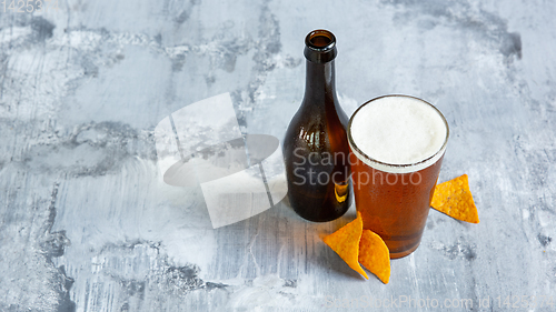 Image of Glass of light beer on white stone background