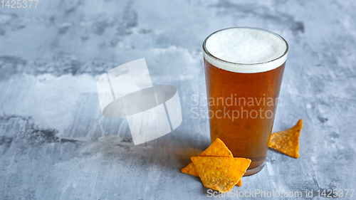 Image of Glass of light beer on white stone background