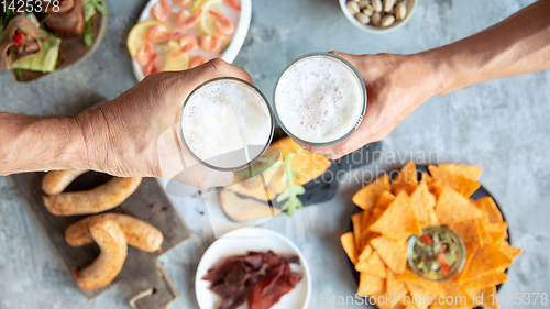 Image of Top view of beer glasses with foam on top and delicious snacks