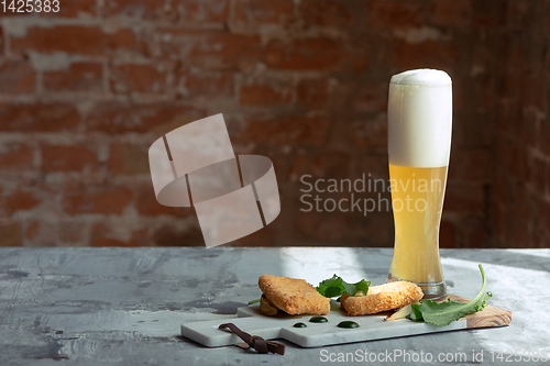 Image of Glass of light beer on the stone table and brick\'s background