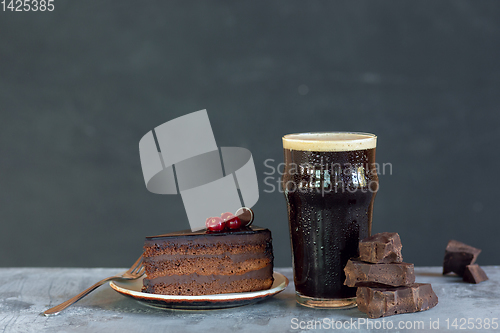 Image of Glass of dark beer on the stone table and grey background