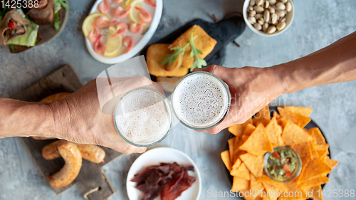 Image of Top view of beer glasses with foam on top and delicious snacks