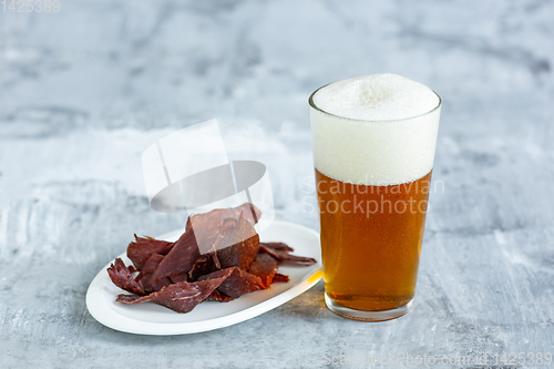 Image of Glass of beer on the stone table and brick\'s background