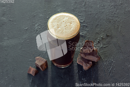 Image of Glass of dark beer on the stone table background