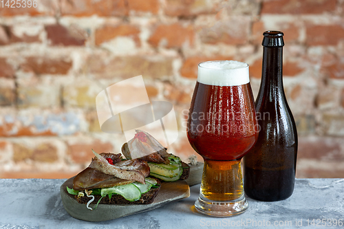 Image of Glass of beer on the stone table and brick\'s background