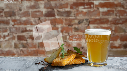 Image of Glass of light beer on the stone table and brick\'s background