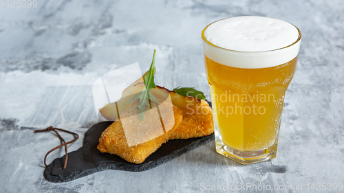 Image of Glass of light beer on white stone background