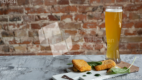 Image of Glass of light beer on the stone table and brick\'s background