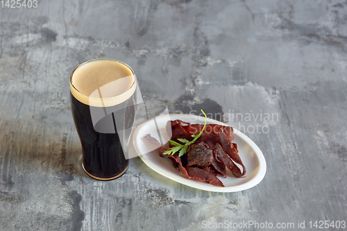 Image of Glass of dark beer on the stone table and brick\'s background