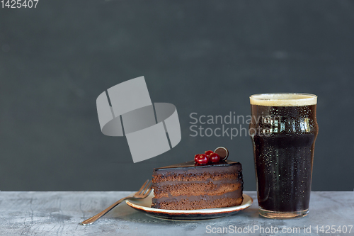 Image of Glass of dark beer on the stone table and grey background