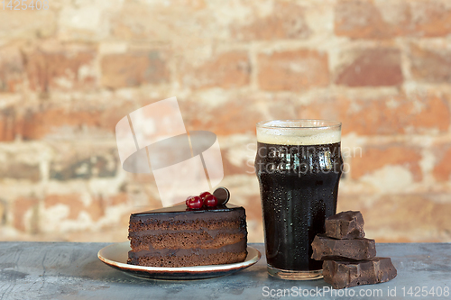 Image of Glass of dark beer on the stone table and brick\'s background