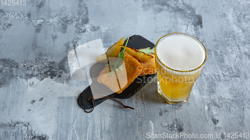 Image of Glass of light beer on white stone background