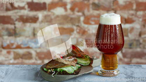 Image of Glass of beer on the stone table and brick\'s background