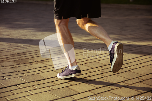 Image of Senior man as runner with armband or fitness tracker at the city\'s street