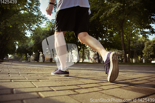 Image of Senior man as runner with armband or fitness tracker at the city\'s street