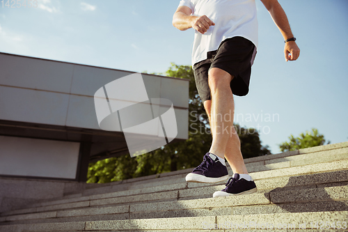 Image of Senior man as runner with armband or fitness tracker at the city\'s street