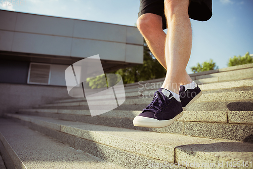 Image of Senior man as runner with armband or fitness tracker at the city\'s street