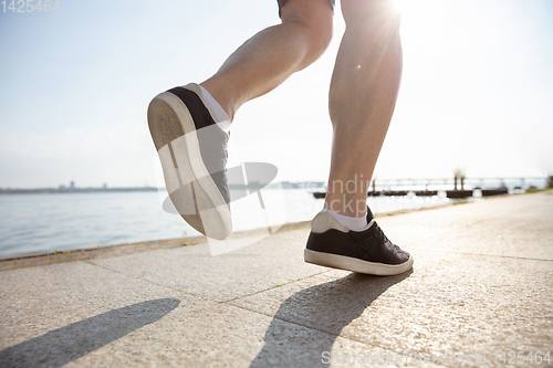 Image of Senior man as runner with armband or fitness tracker at the riverside