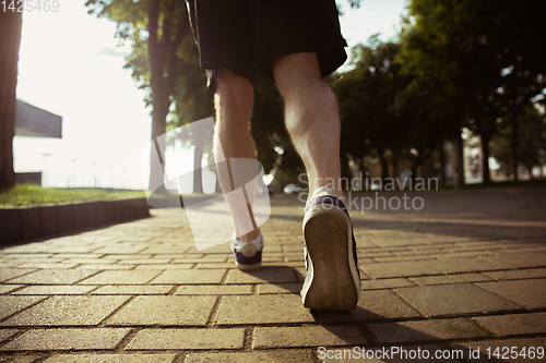 Image of Senior man as runner with armband or fitness tracker at the city\'s street