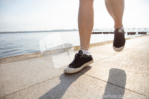 Image of Senior man as runner with armband or fitness tracker at the riverside