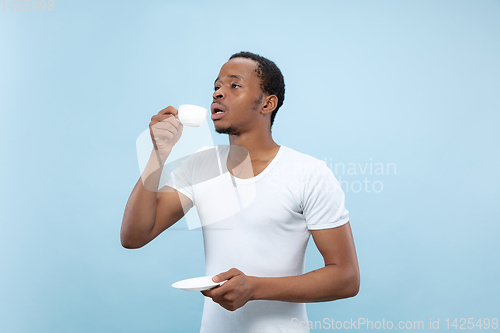 Image of Half-length close up portrait of young man on blue background.