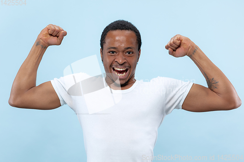 Image of Half-length close up portrait of young man on blue background.