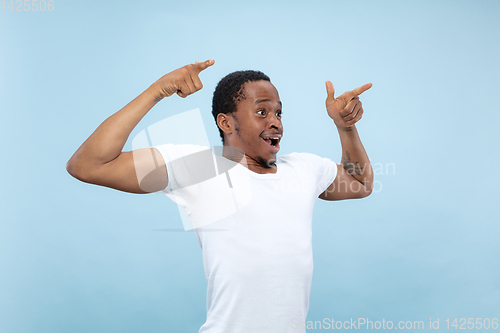 Image of Half-length close up portrait of young man on blue background.