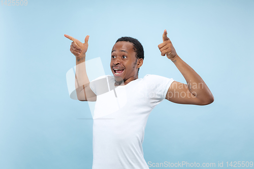 Image of Half-length close up portrait of young man on blue background.