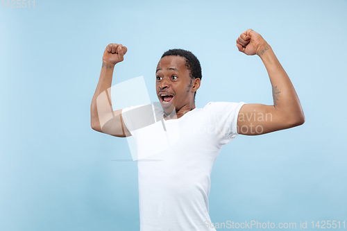 Image of Half-length close up portrait of young man on blue background.