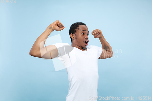 Image of Half-length close up portrait of young man on blue background.