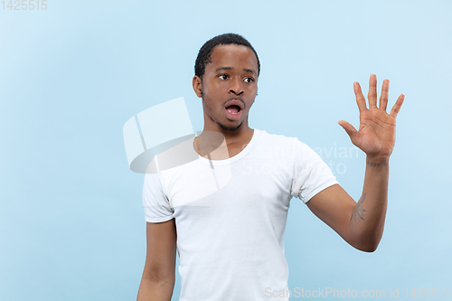 Image of Half-length close up portrait of young man on blue background.