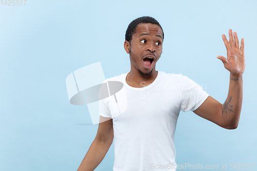 Image of Half-length close up portrait of young man on blue background.