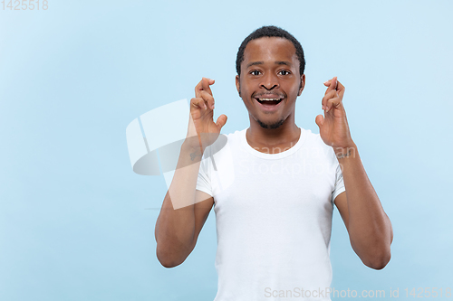 Image of Half-length close up portrait of young man on blue background.