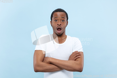 Image of Half-length close up portrait of young man on blue background.