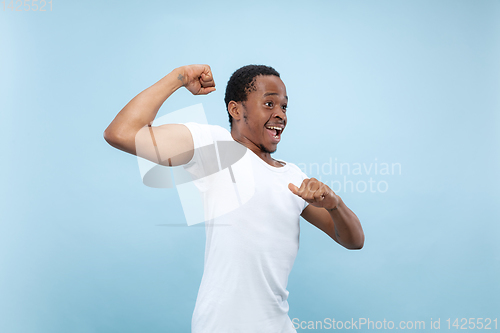 Image of Half-length close up portrait of young man on blue background.