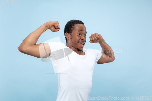 Image of Half-length close up portrait of young man on blue background.