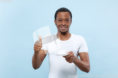 Image of Half-length close up portrait of young man on blue background.