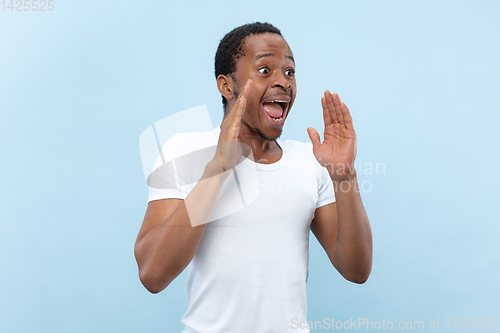 Image of Half-length close up portrait of young man on blue background.