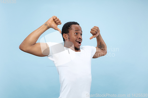 Image of Half-length close up portrait of young man on blue background.