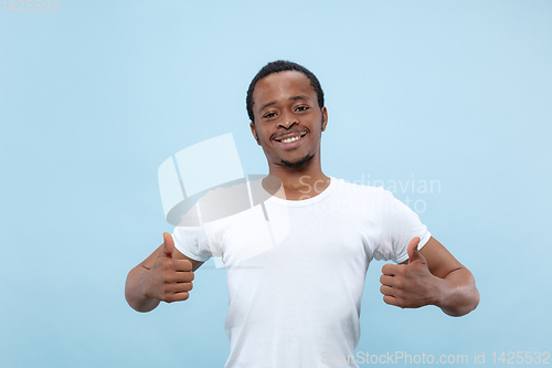 Image of Half-length close up portrait of young man on blue background.