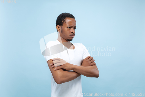 Image of Half-length close up portrait of young man on blue background.