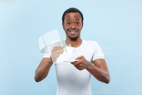 Image of Half-length close up portrait of young man on blue background.