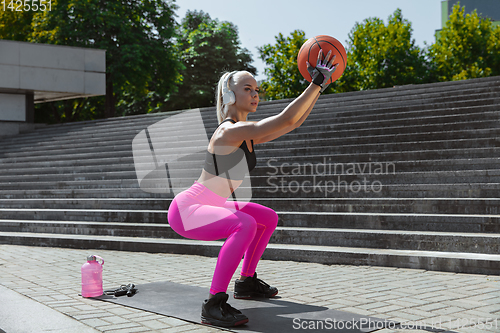 Image of A young athletic woman working out at the city\'s street