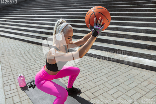 Image of A young athletic woman working out at the city\'s street