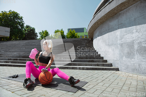 Image of A young athletic woman working out at the city\'s street